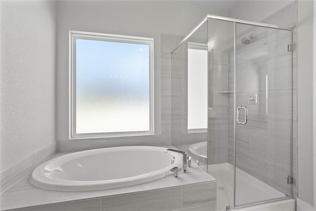 bathroom featuring shower with separate bathtub