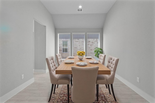 dining area featuring light hardwood / wood-style flooring and lofted ceiling