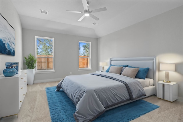 bedroom featuring light colored carpet, lofted ceiling, and ceiling fan