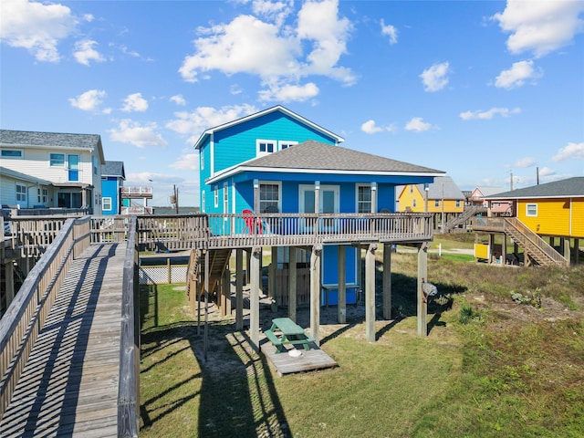 211 Ocean Dr, Surfside Beach, TX 77541 - rear view of property with a wooden deck, stairway, a yard, roof with shingles, and a carport