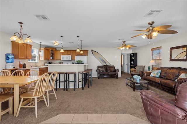 carpeted living room with sink and ceiling fan with notable chandelier