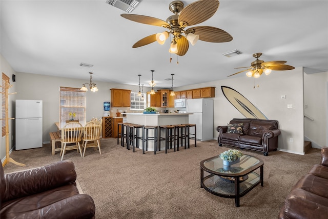 carpeted living room with ceiling fan with notable chandelier