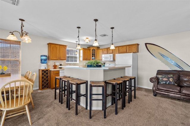 kitchen featuring hanging light fixtures, white appliances, light colored carpet, and a center island