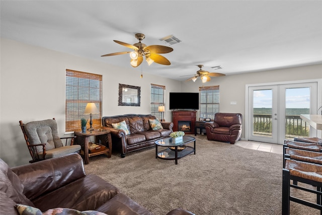 211 Ocean Dr, Surfside Beach, TX 77541 - carpeted living area with a ceiling fan, a lit fireplace, tile patterned flooring, and french doors