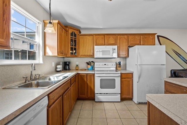 211 Ocean Dr, Surfside Beach, TX 77541 - kitchen with white appliances, brown cabinetry, and glass insert cabinets