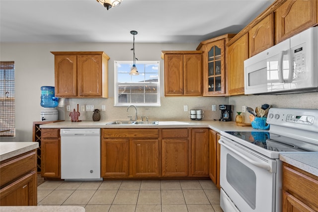 kitchen featuring pendant lighting, white appliances, sink, and light tile patterned floors