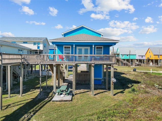 211 Ocean Dr, Surfside Beach, TX 77541 - rear view of house with a wooden deck, stairway, a lawn, a carport, and roof with shingles