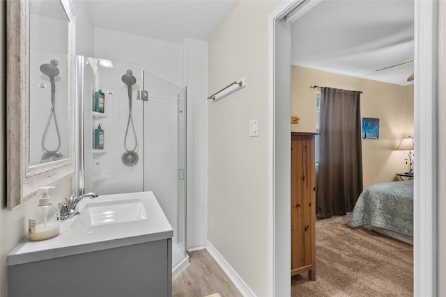 bathroom with an enclosed shower, vanity, and wood-type flooring