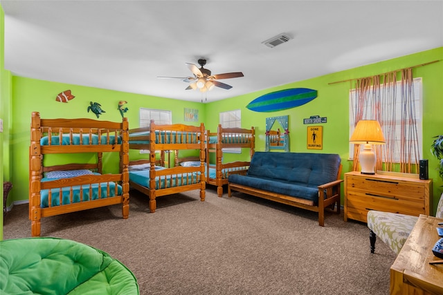 carpeted bedroom featuring multiple windows and ceiling fan