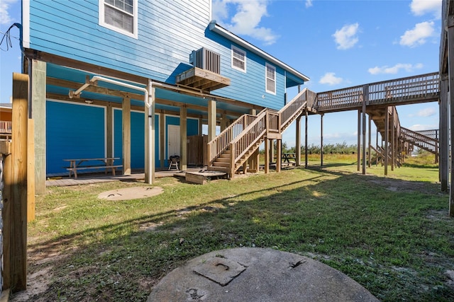211 Ocean Dr, Surfside Beach, TX 77541 - back of house with stairway, a lawn, and a deck