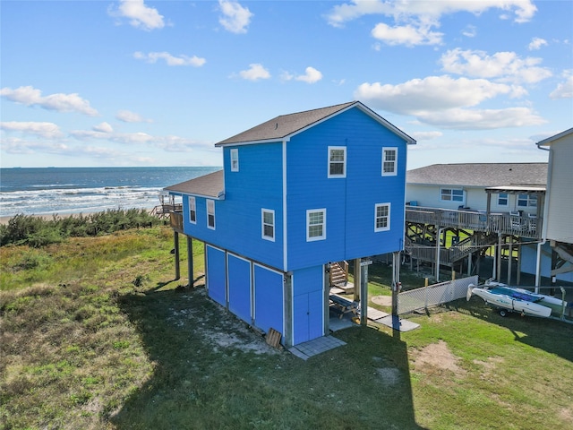 211 Ocean Dr, Surfside Beach, TX 77541 - view of property exterior with stairway, a water view, a lawn, a shingled roof, and driveway