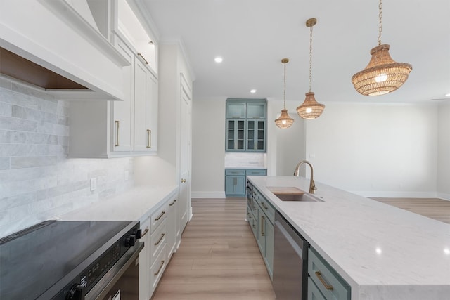 kitchen featuring electric range oven, decorative light fixtures, decorative backsplash, sink, and a kitchen island with sink