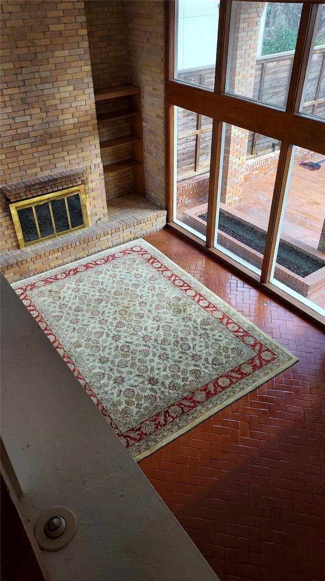 unfurnished living room featuring a brick fireplace