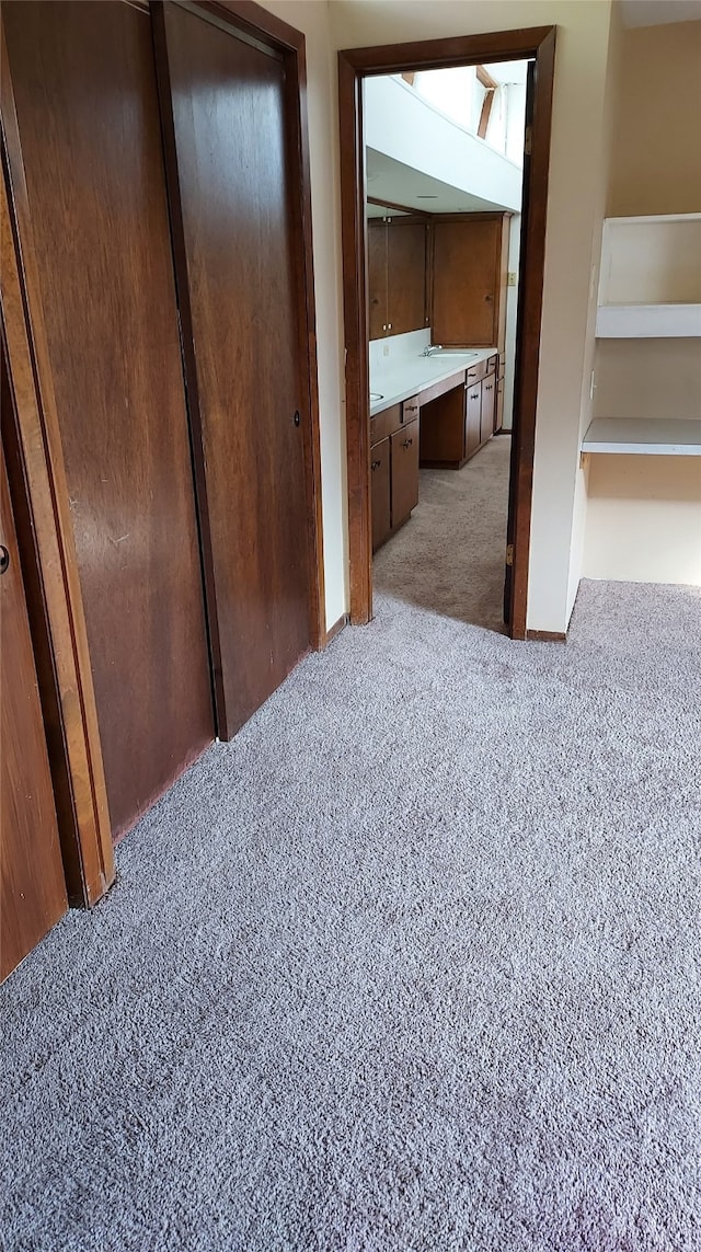 bedroom featuring built in desk and light colored carpet