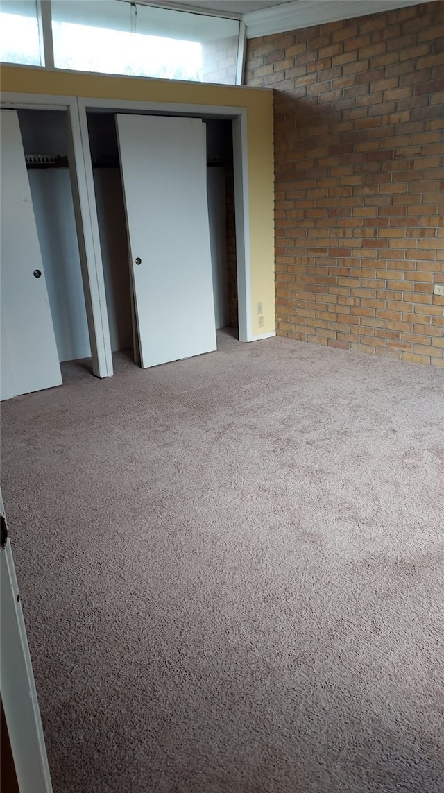 basement featuring carpet flooring and brick wall