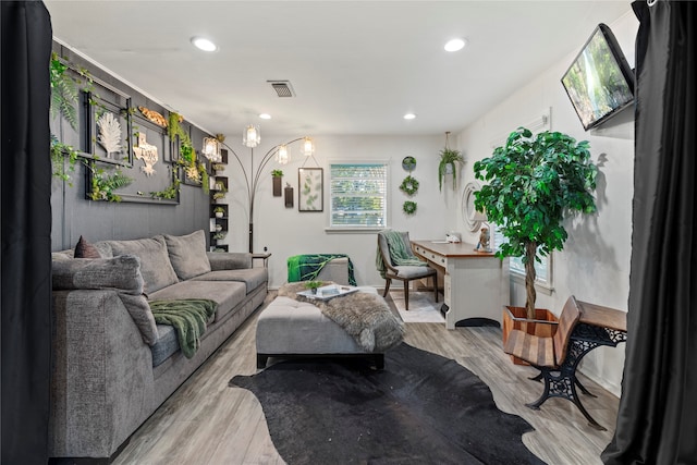 living room with a skylight and light hardwood / wood-style floors