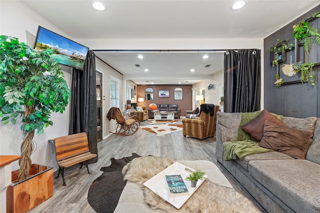 living room with ornamental molding and light hardwood / wood-style flooring