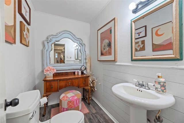 bathroom with toilet, sink, hardwood / wood-style floors, and crown molding