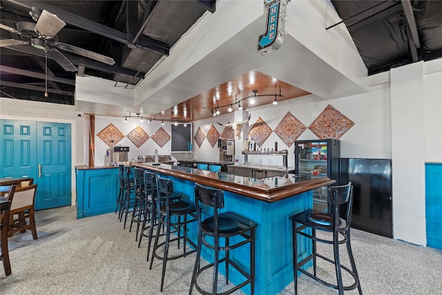 kitchen with kitchen peninsula, rail lighting, a kitchen breakfast bar, and blue cabinets