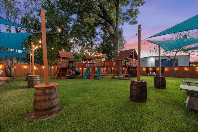 yard at dusk featuring a playground