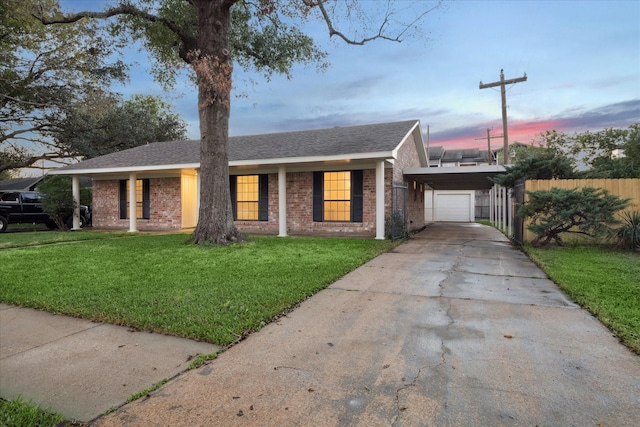 view of front facade featuring a yard, a carport, and a garage