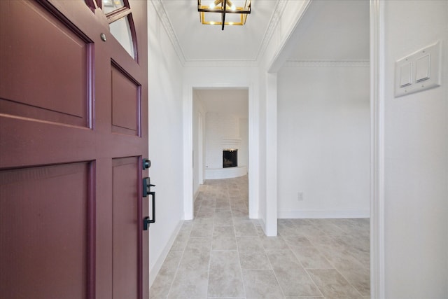 tiled entryway with a brick fireplace and ornamental molding