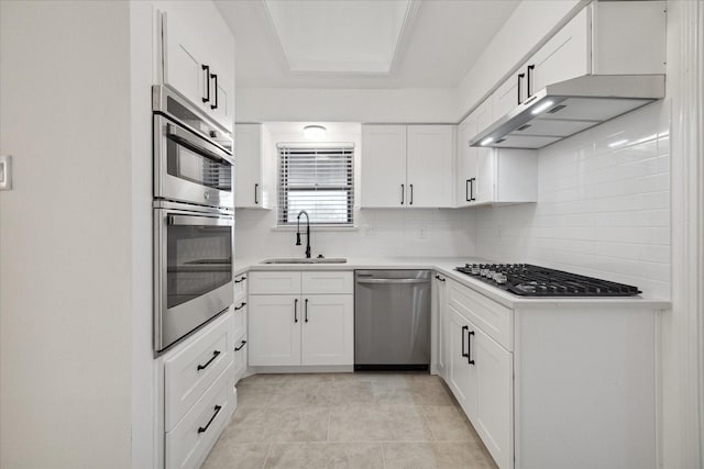 kitchen featuring stainless steel appliances, sink, white cabinetry, light tile patterned flooring, and tasteful backsplash