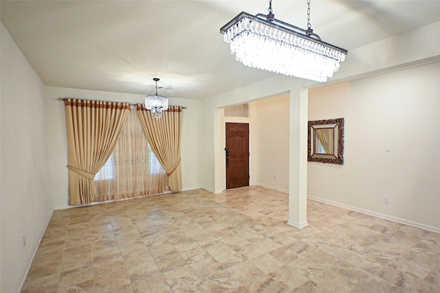 spare room featuring an inviting chandelier