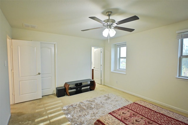 carpeted bedroom with multiple windows and ceiling fan