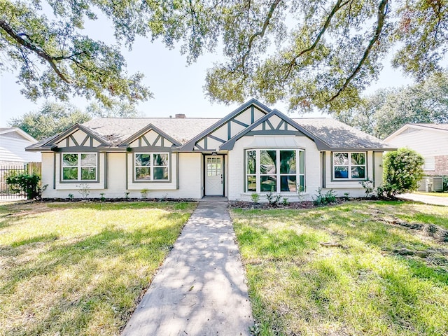 tudor home featuring central AC unit and a front yard