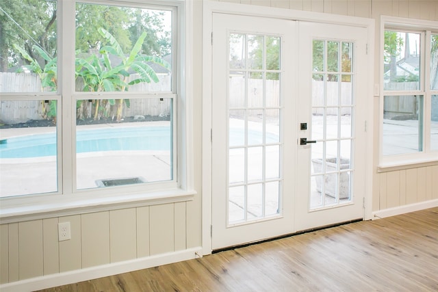 doorway to outside with a healthy amount of sunlight, light hardwood / wood-style flooring, and french doors