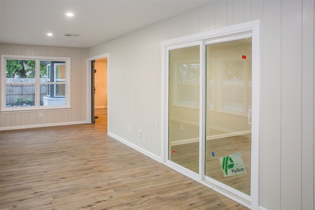 empty room featuring light hardwood / wood-style flooring and wood walls