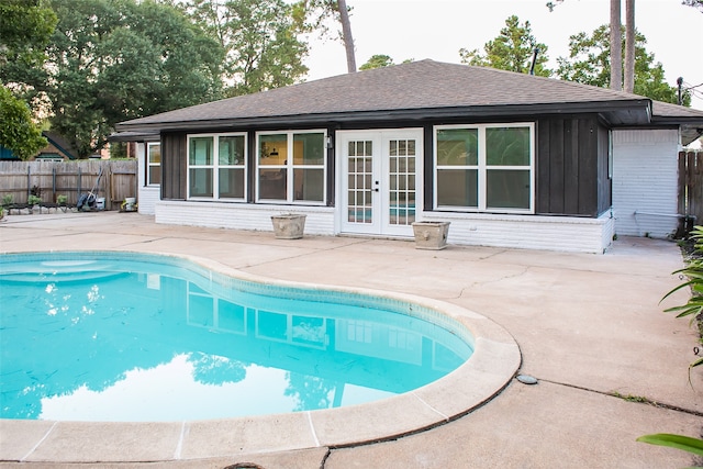 view of swimming pool with a patio and french doors