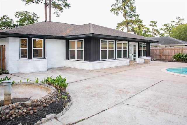 back of property featuring a fenced in pool and a patio