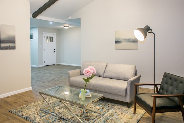 living room featuring wood-type flooring and lofted ceiling with beams