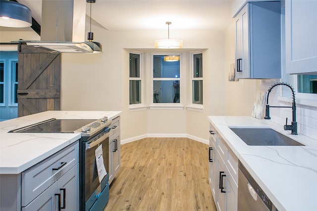 kitchen featuring pendant lighting, ventilation hood, appliances with stainless steel finishes, and light stone countertops