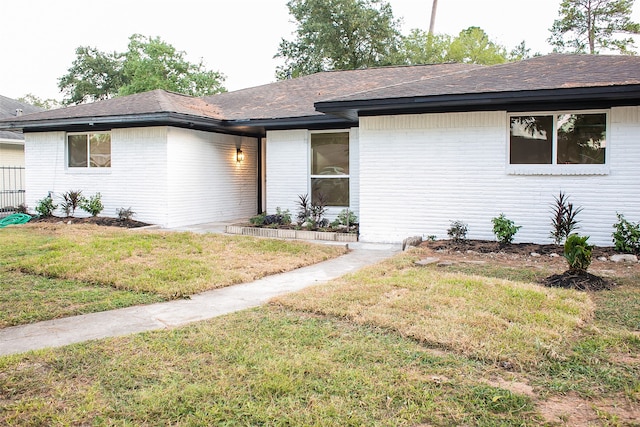 single story home with a front lawn