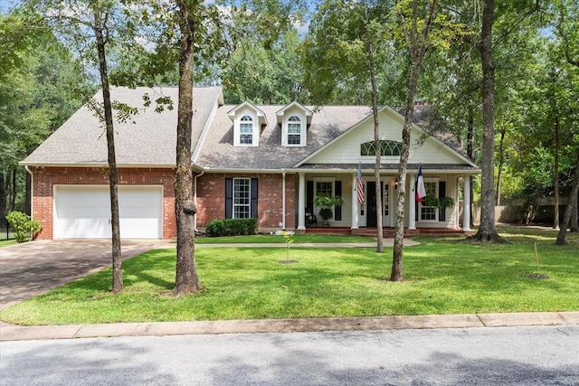 cape cod home with a porch, a front yard, and a garage