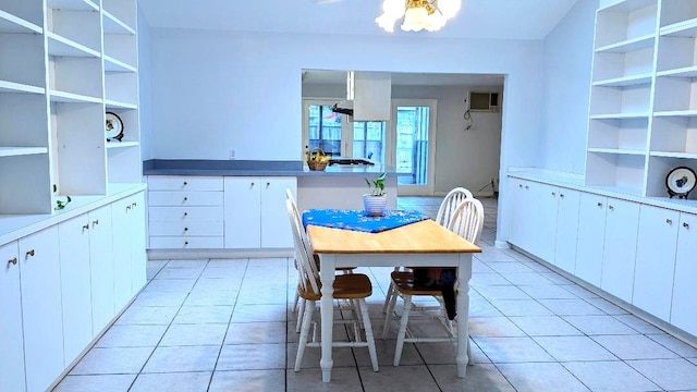 kitchen with an AC wall unit, light tile patterned flooring, and white cabinets