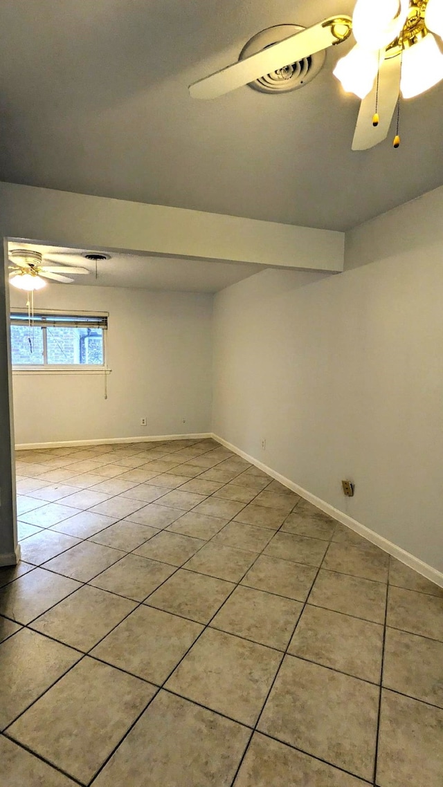 tiled spare room featuring ceiling fan