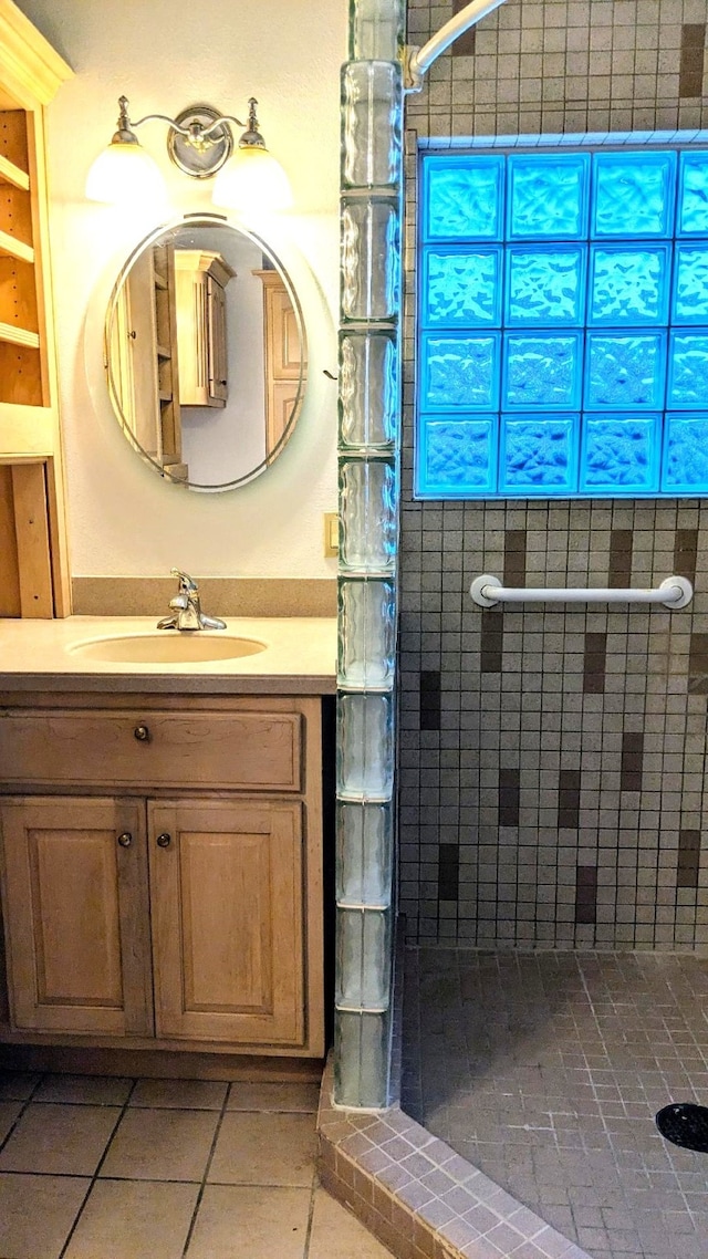 bathroom with vanity, tile patterned floors, and a tile shower