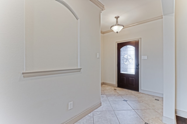 foyer entrance with light tile patterned floors and crown molding