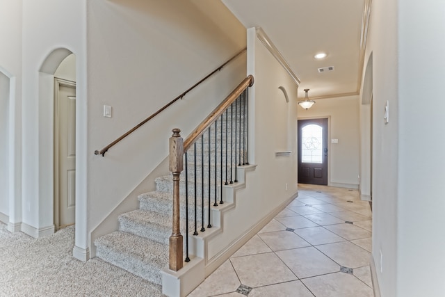 entrance foyer with ornamental molding and light tile patterned flooring