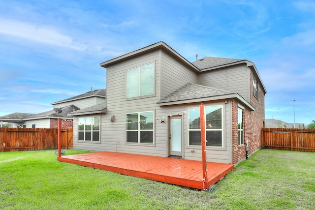 back of house featuring a lawn and a wooden deck