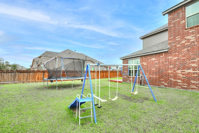 view of yard featuring a playground and a trampoline