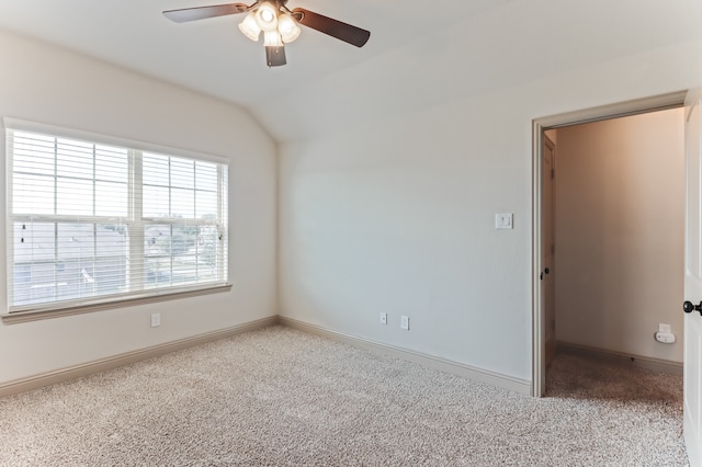 empty room with ceiling fan, light colored carpet, and vaulted ceiling