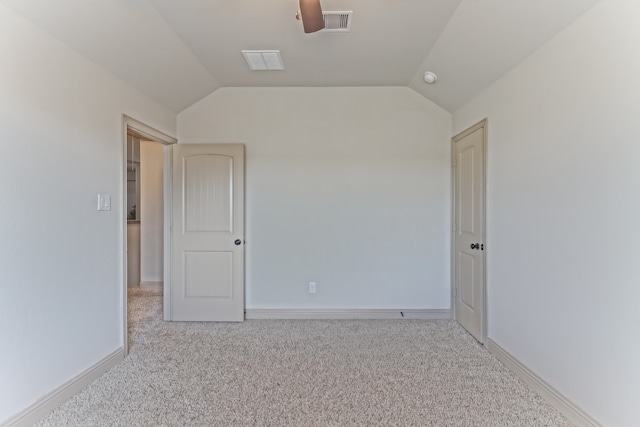 carpeted empty room featuring lofted ceiling