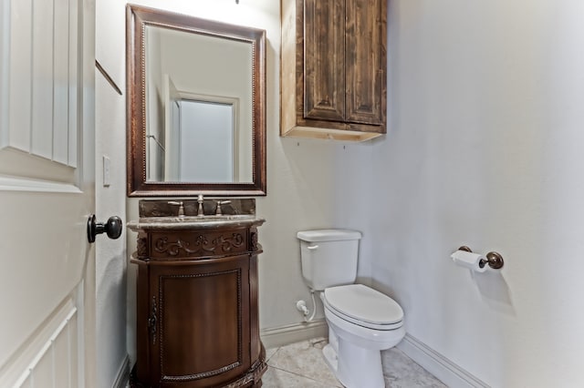 bathroom with toilet, vanity, and tile patterned floors