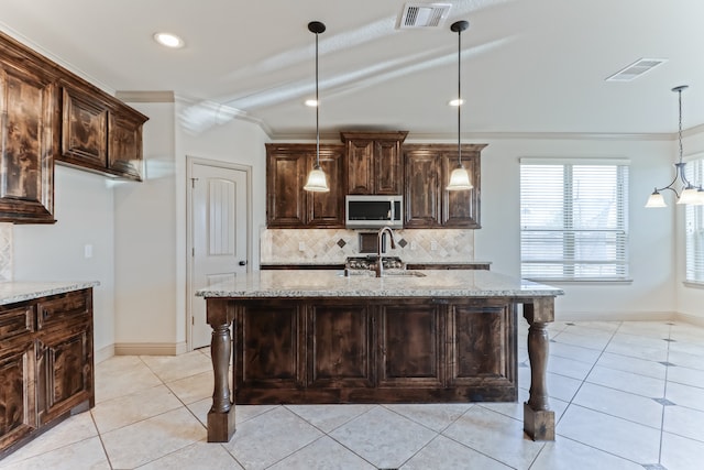 kitchen featuring lofted ceiling, a breakfast bar, and light stone countertops