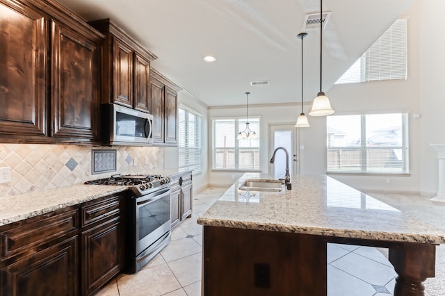 kitchen featuring appliances with stainless steel finishes, sink, crown molding, and light stone countertops